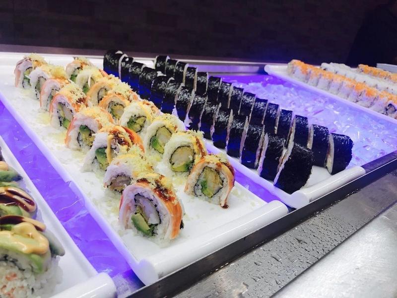 Rows of sushi rolls on the chilled sushi bar